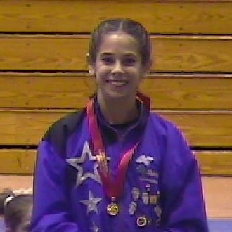 Young gymnast in a leotard, pictured at a gymnastics event or meet