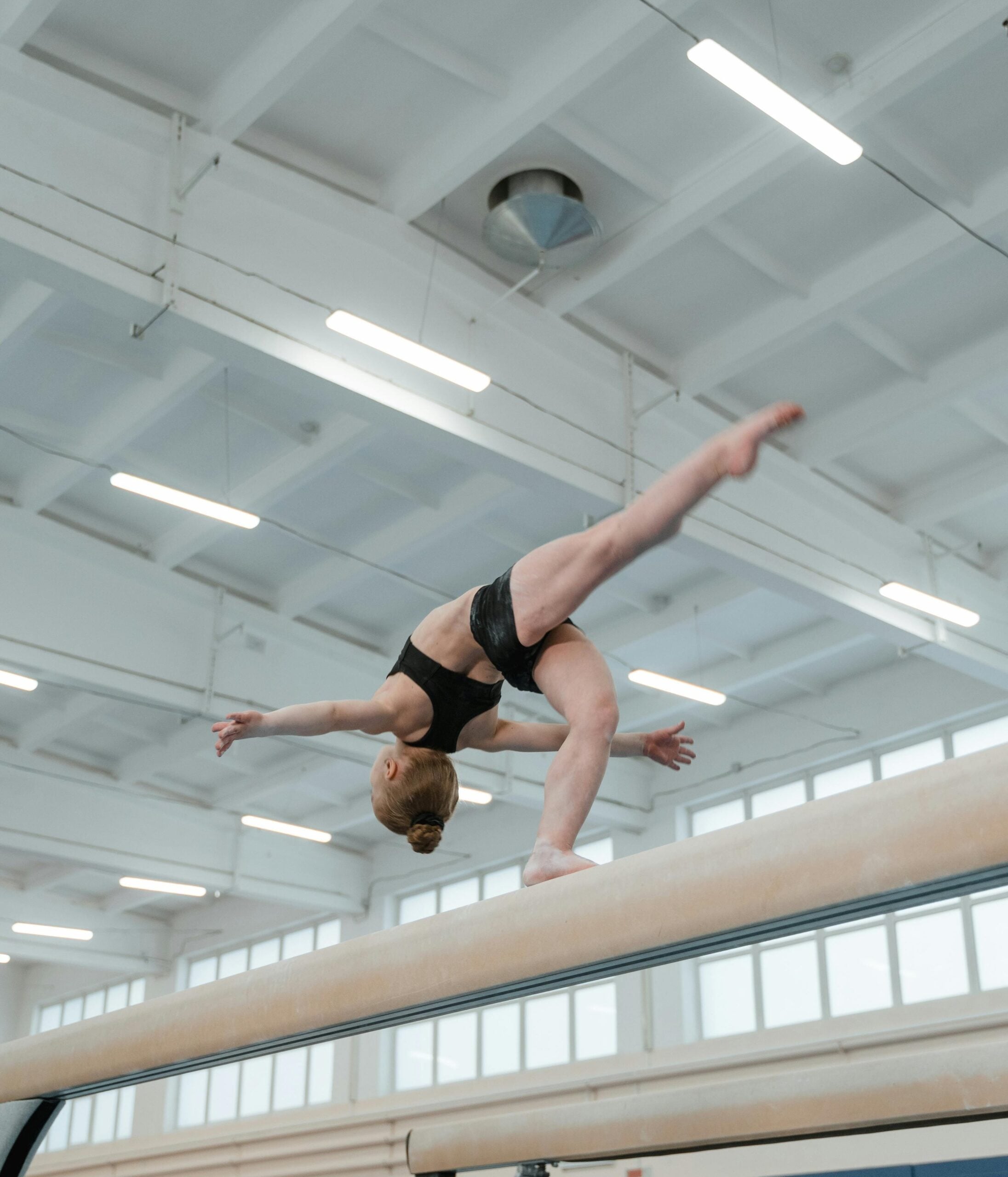 Gymnast performing an aerial skill, captured mid-flight