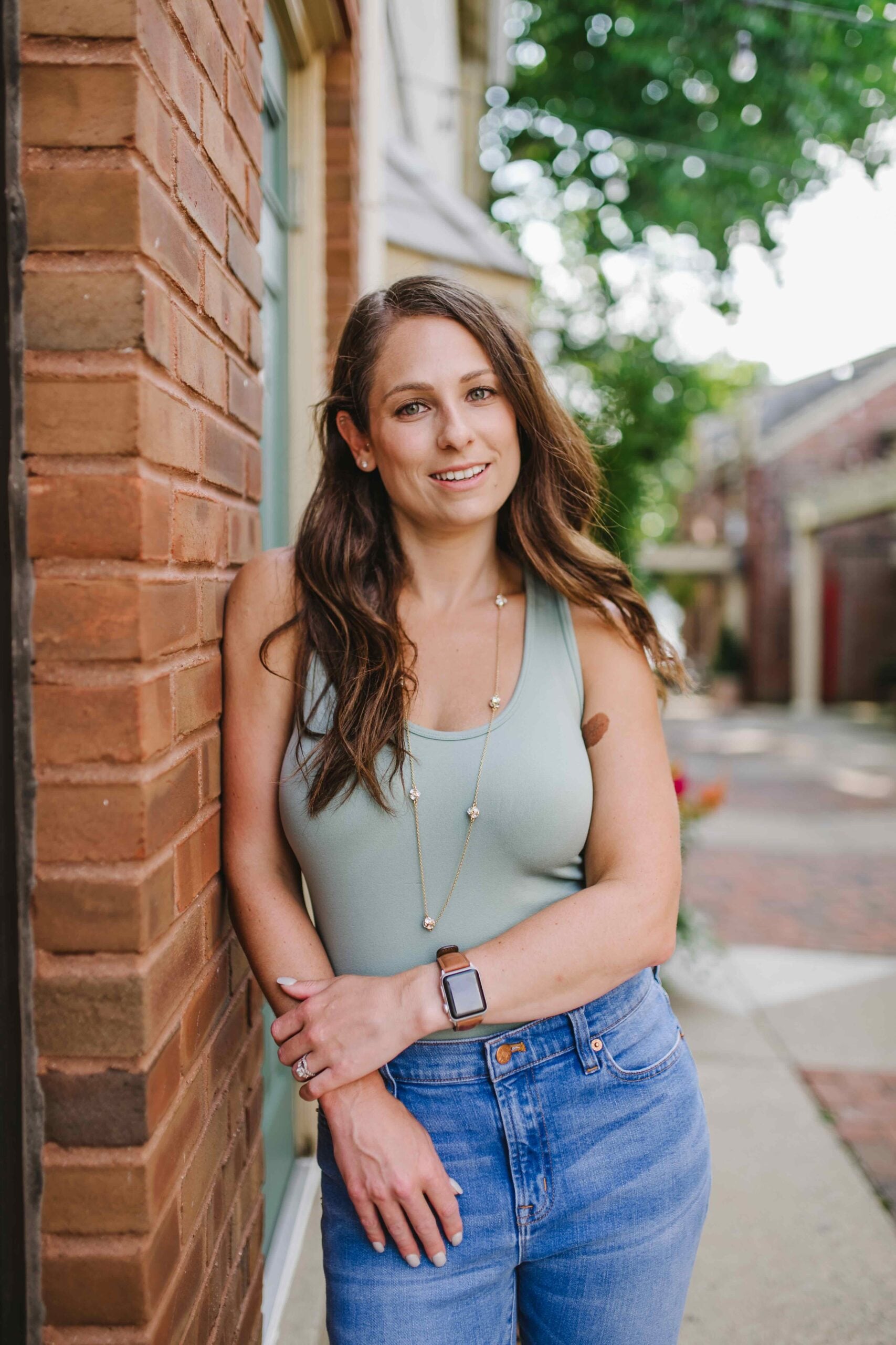 Kerry, Board-Certified Sports Dietitian for Gymnasts, smiling outdoors in front of a brick wall