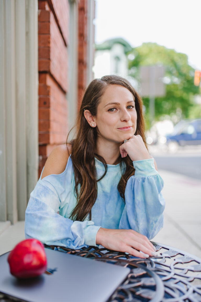 Kerry, Board-Certified Sports Dietitian for Gymnasts, smiling outdoors in front of a brick wall