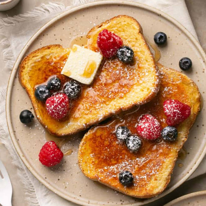 Homemade Berry Protein French Toast served on a plate, topped with fresh berries and a dollop of Greek yogurt.