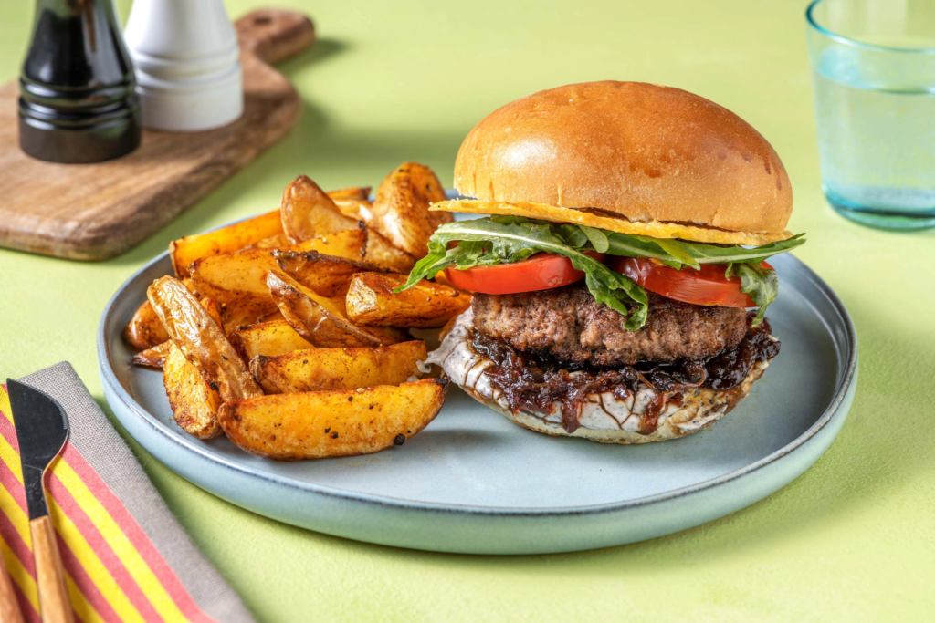 A plate featuring a juicy turkey burger on a toasted whole grain bun alongside a generous serving of golden, oven-baked potato wedges.