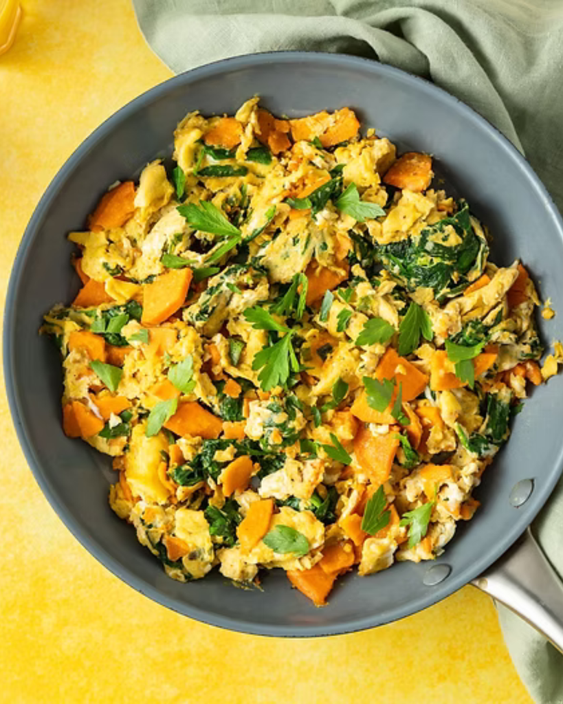 Power scramble featuring eggs, spinach, leftover potatoes, cheese, and beans served in a bowl.